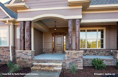 Stone steps leading to covered front porch. The Travis plan 1350.