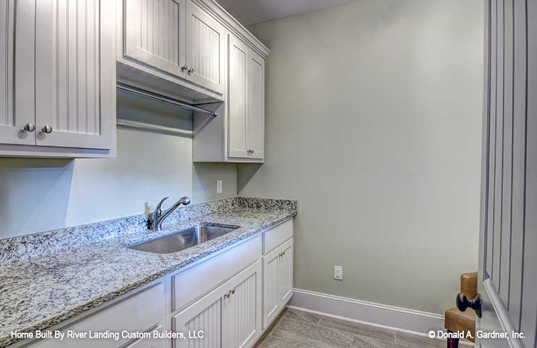 Plenty of storage and counter space in the utility room in one story house plan 1341 The Tucker