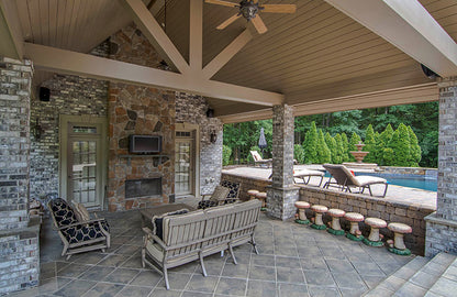 Outdoor fireplace and seating in the pool house. The Wedgewood plan 806.