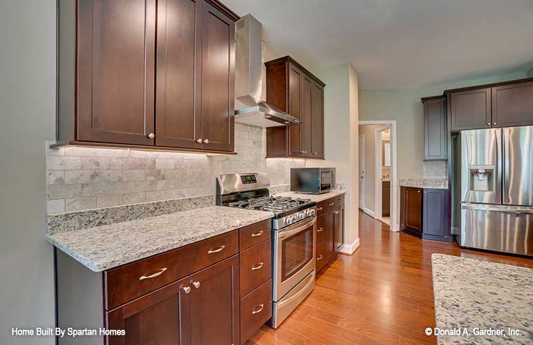 Tile back splash and brown cabinets in the kitchen. The Westlake plan 1332.