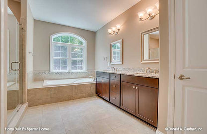 Double sink vanity and arched window in the master bathroom. The Westlake plan 1332.