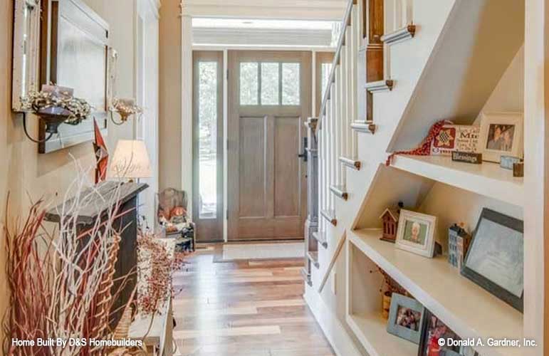 Built in shelves under the stairs in the foyer. The Wexler plan 1248.