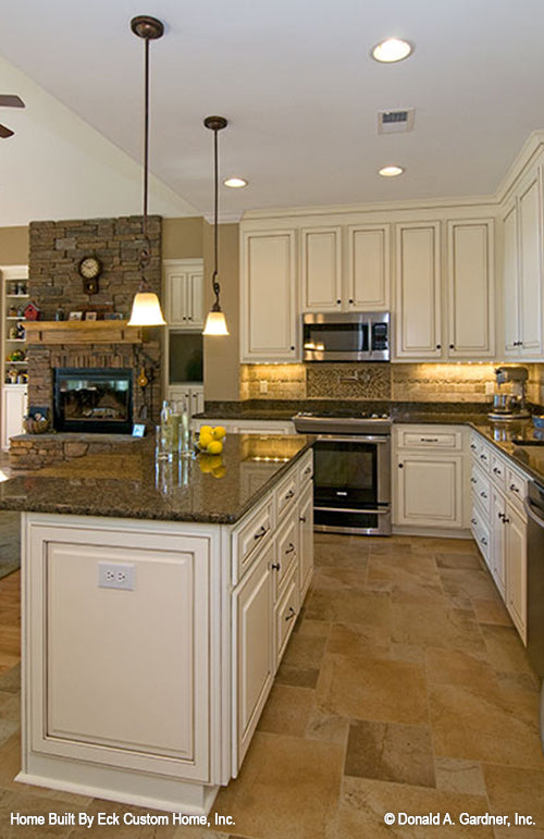 Kitchen view of the island with the great room fireplace in the back.  The Whitcomb plan 1218.