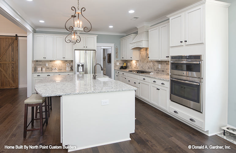 Kitchen island with a sink and seating. The Wilkerson plan 1296.