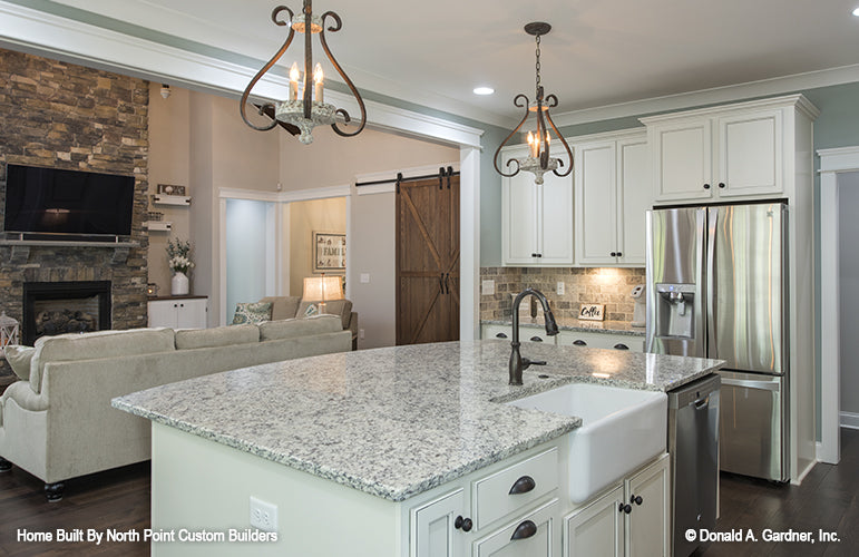 White cabinets and stainless-steel fridge in the kitchen. The Wilkerson plan 1296.