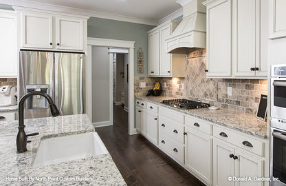 Countertop gas stover with hood above in the kitchen. The Wilkerson plan 1296.