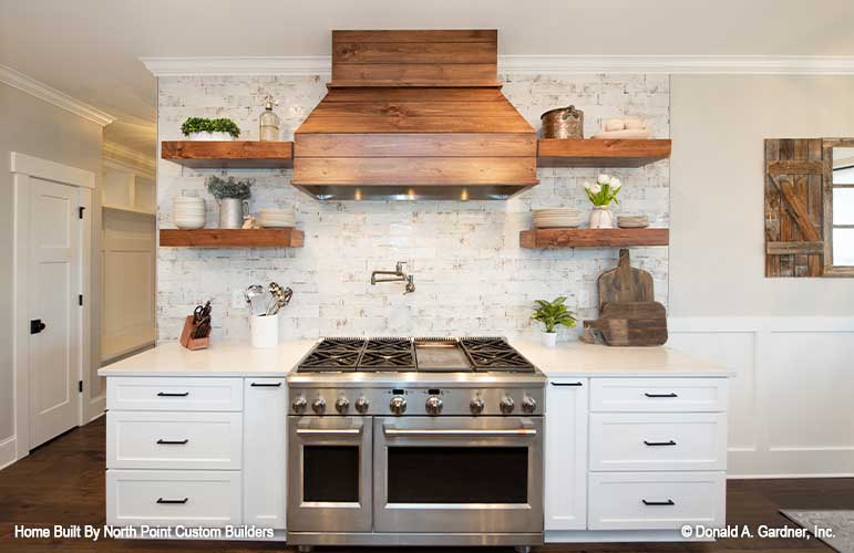 Wood range hood and shelves in the kitchen. The Zander plan 1478.