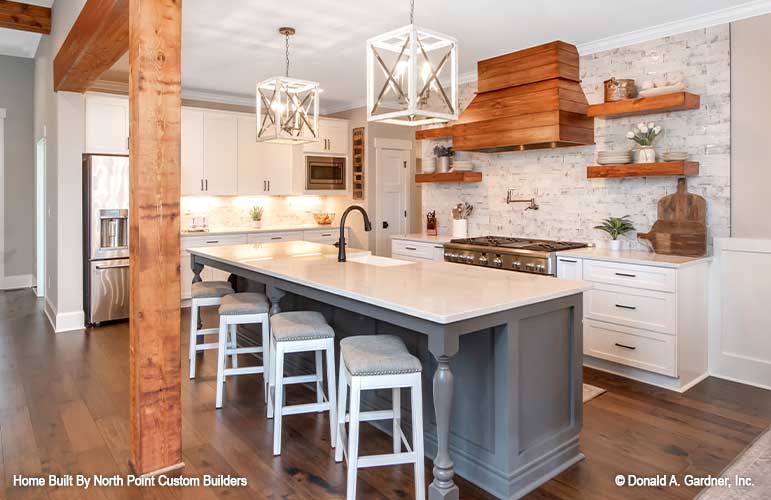 Large island with seating and a sink in the kitchen. The Zander plan 1478.