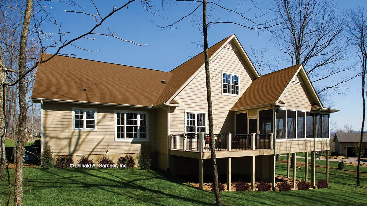 Rear view photograph with a screened in porch and deck. The Zeller plan 1014.